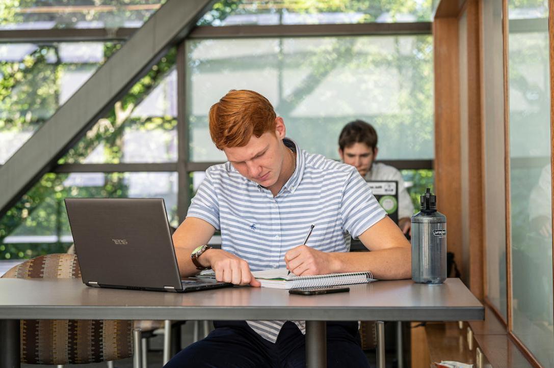 Student on the sky bridge studying and writing.